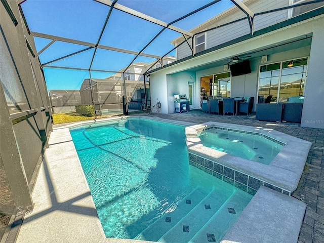 view of pool with an in ground hot tub, a patio, ceiling fan, and a lanai