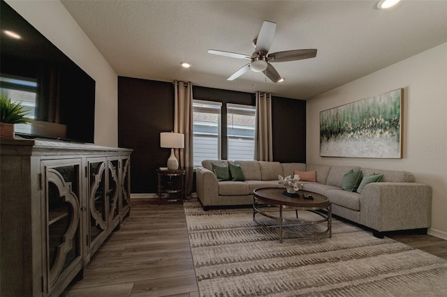 living room with ceiling fan, a textured ceiling, and hardwood / wood-style flooring