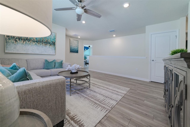 living room with ceiling fan and light hardwood / wood-style flooring