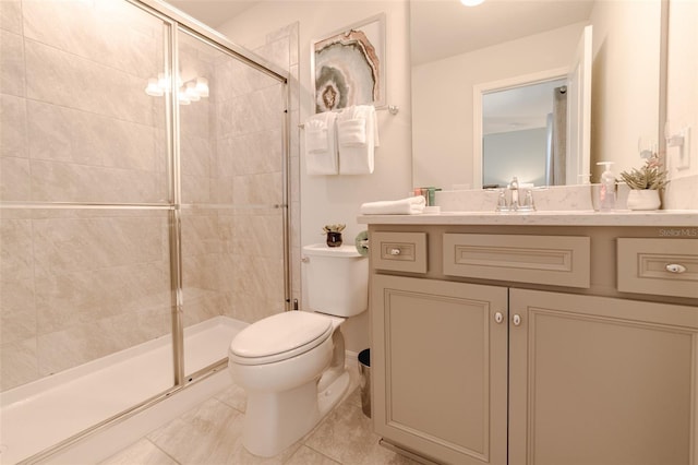 bathroom featuring tile patterned floors, vanity, toilet, and a shower with shower door