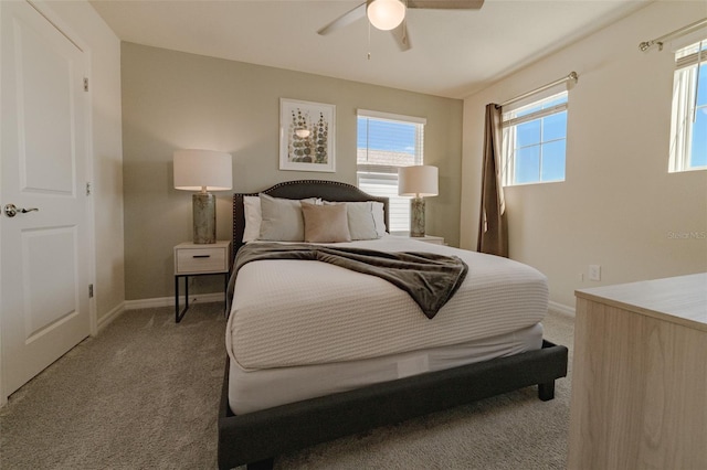 carpeted bedroom with ceiling fan and multiple windows