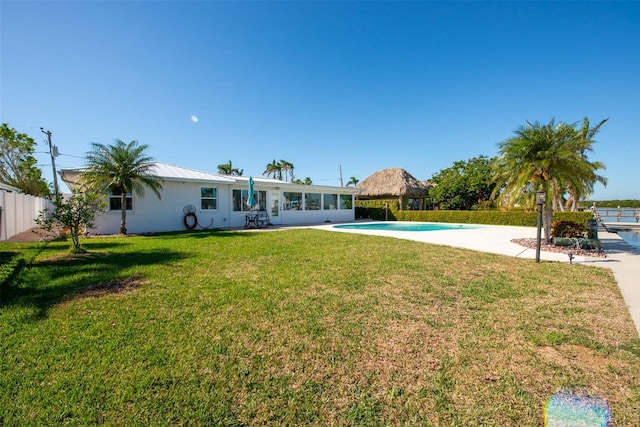 rear view of property featuring a patio area and a lawn