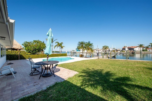 view of yard featuring a patio area, a water view, and a boat dock