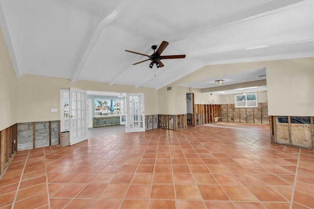 unfurnished living room featuring ceiling fan, french doors, light tile patterned floors, and lofted ceiling with beams