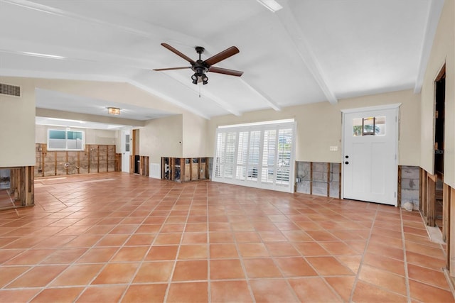 unfurnished living room with ceiling fan, light tile patterned floors, and lofted ceiling with beams