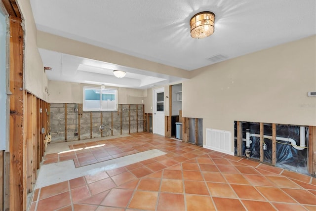 empty room featuring a tray ceiling and light tile patterned floors