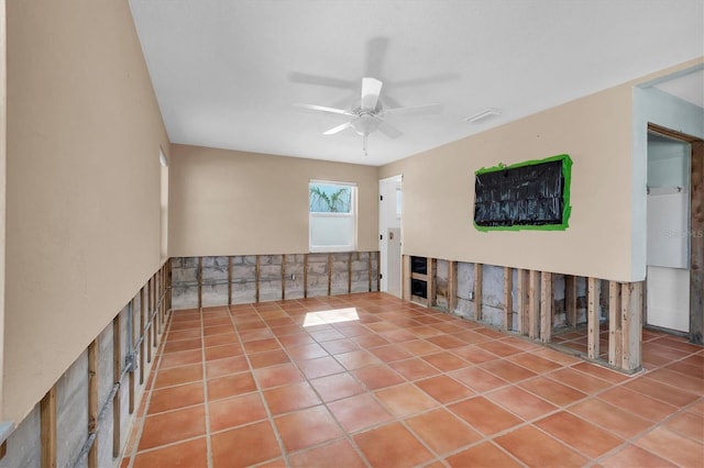 tiled spare room featuring ceiling fan