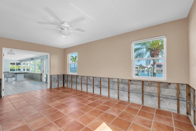 tiled empty room featuring ceiling fan