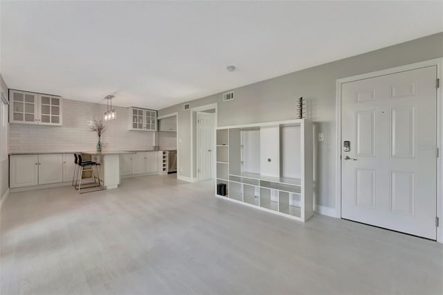 unfurnished living room featuring brick wall