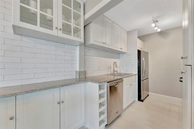 kitchen featuring stainless steel appliances, white cabinetry, tasteful backsplash, and sink