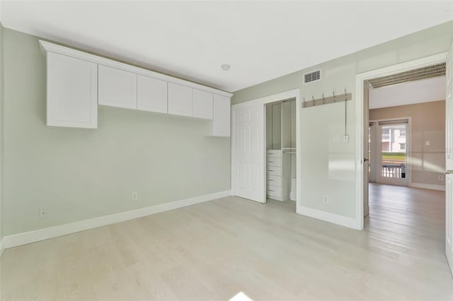 unfurnished bedroom featuring a closet and light hardwood / wood-style flooring