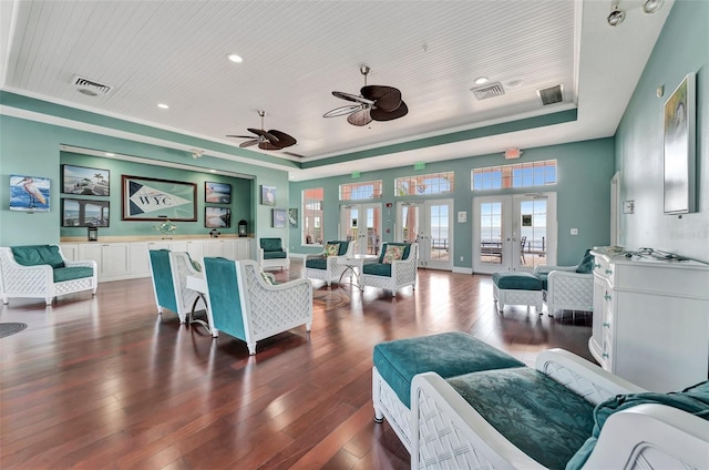 living room with a raised ceiling, dark hardwood / wood-style flooring, french doors, and wood ceiling