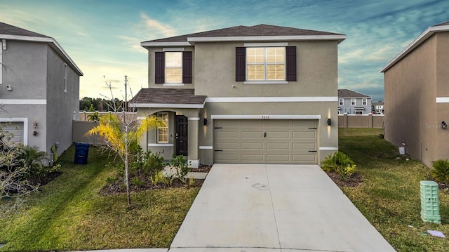 view of property featuring a garage and a front lawn