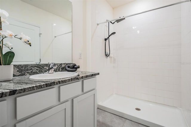 bathroom with tiled shower and vanity