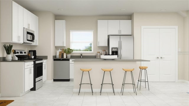 kitchen with a kitchen breakfast bar, white cabinetry, a kitchen island, and stainless steel appliances