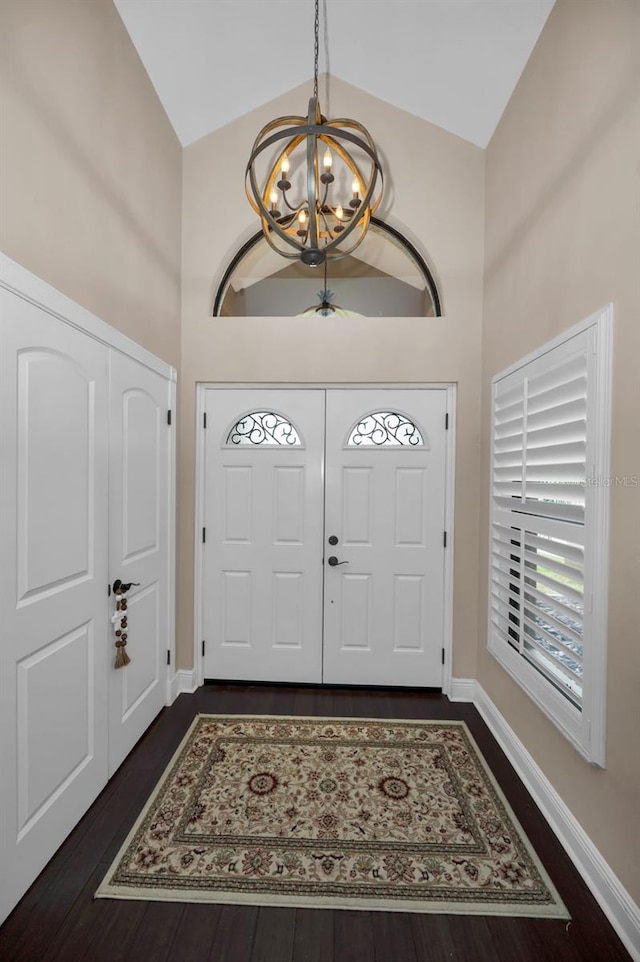 foyer with dark hardwood / wood-style floors, a notable chandelier, and high vaulted ceiling