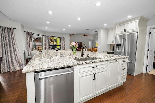 kitchen featuring white cabinetry, stainless steel appliances, sink, and a center island with sink