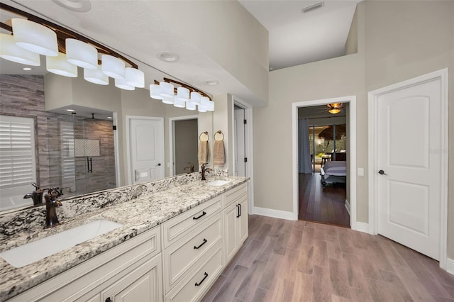 bathroom featuring an enclosed shower, vanity, ceiling fan, hardwood / wood-style floors, and a high ceiling