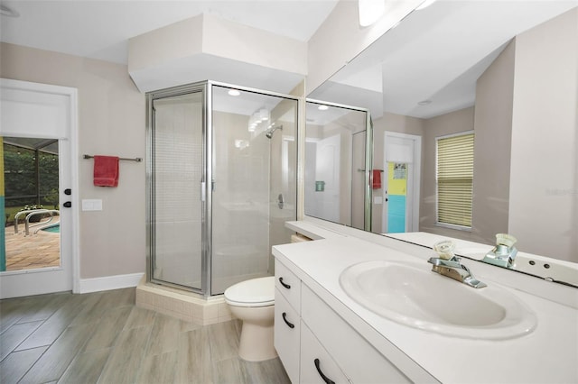 bathroom with a healthy amount of sunlight, vanity, toilet, and a shower with door