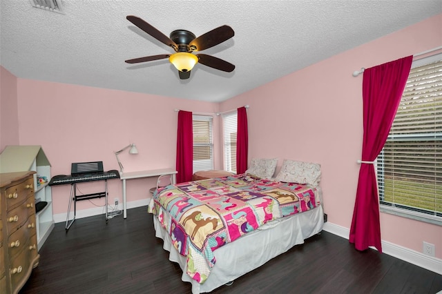 bedroom featuring dark hardwood / wood-style flooring, a textured ceiling, and ceiling fan