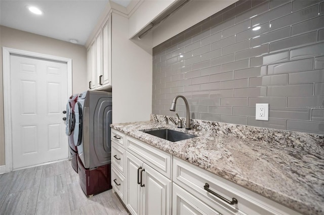 laundry area with cabinets, sink, and washer and dryer