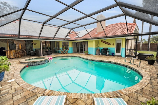 view of swimming pool featuring an in ground hot tub, a lanai, an outdoor bar, and a patio