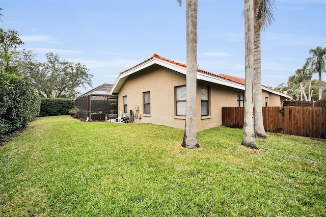 back of property with a lanai and a lawn