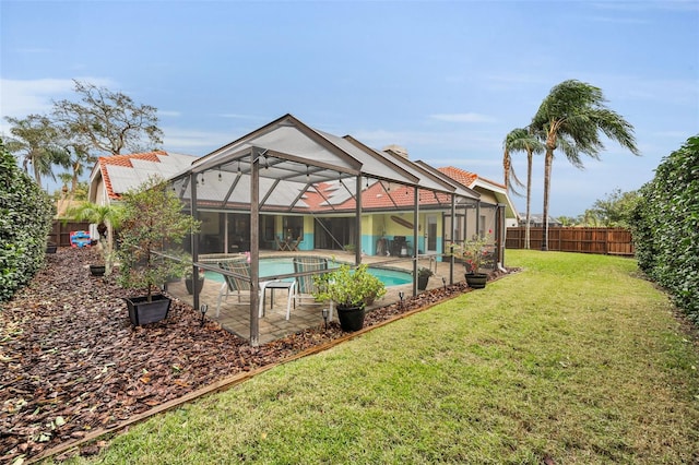 view of pool featuring a yard, a patio area, and glass enclosure