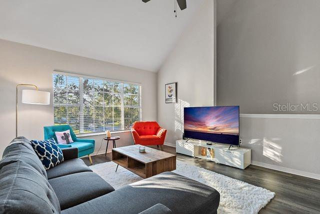 living room featuring ceiling fan, dark hardwood / wood-style flooring, and high vaulted ceiling