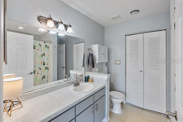 bathroom with vanity, curtained shower, and toilet