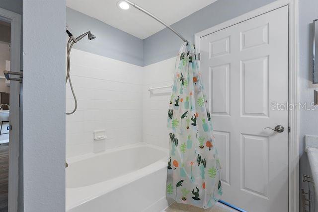 bathroom with shower / tub combo with curtain