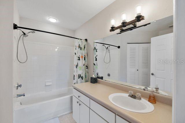 bathroom featuring shower / bath combo with shower curtain and vanity