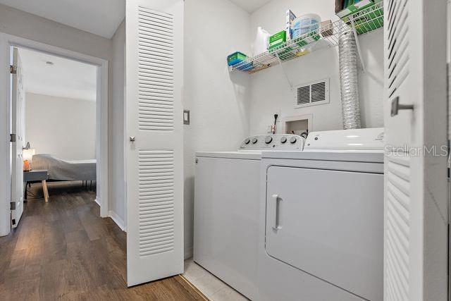 laundry room featuring washer and dryer and dark hardwood / wood-style flooring