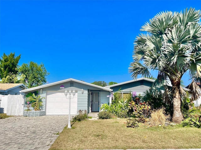 ranch-style home with a garage and a front lawn