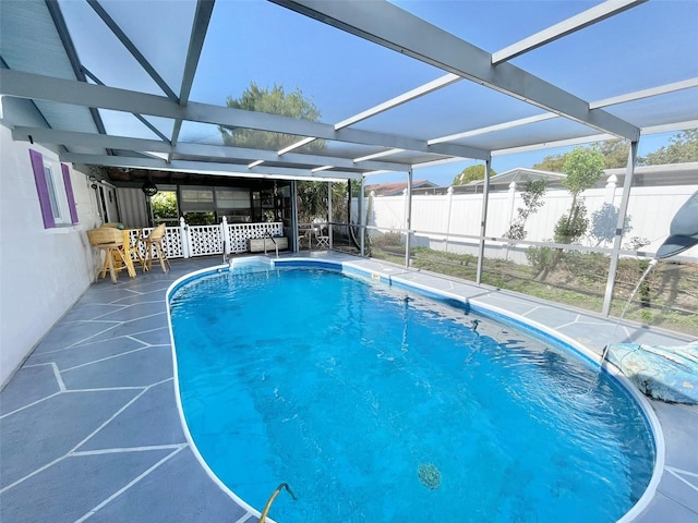 view of swimming pool with glass enclosure and a patio area