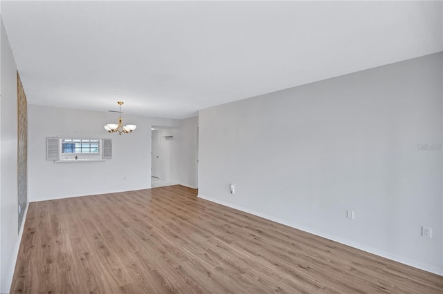 unfurnished living room with light hardwood / wood-style floors and an inviting chandelier