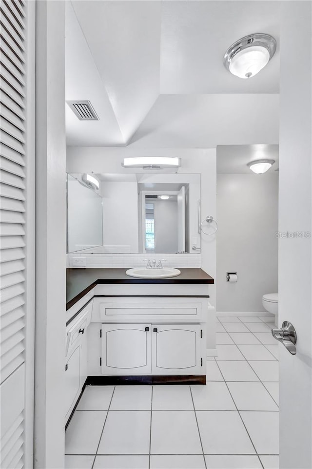 bathroom with tile patterned flooring, vanity, and toilet