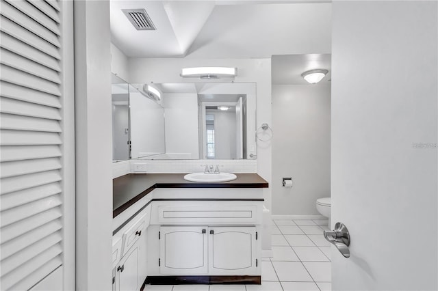 bathroom featuring tile patterned flooring, vanity, and toilet