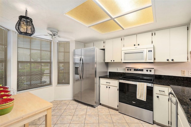 kitchen featuring white cabinetry, ceiling fan, stainless steel appliances, dark stone counters, and light tile patterned flooring