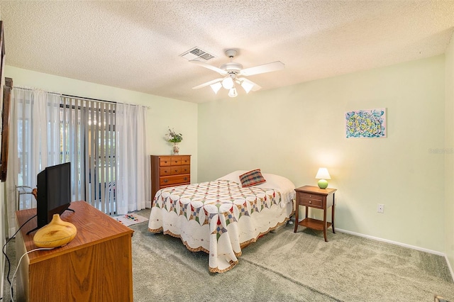 bedroom with ceiling fan, carpet, and a textured ceiling