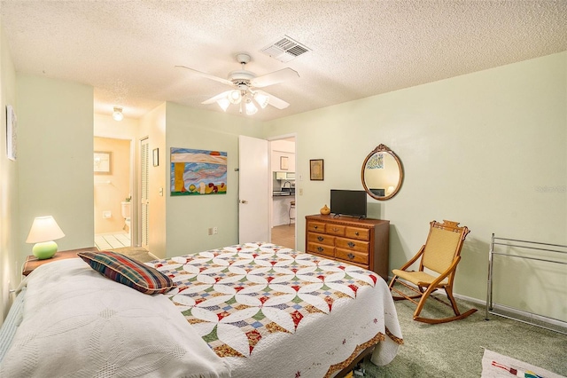 carpeted bedroom featuring ceiling fan, a textured ceiling, connected bathroom, and a closet