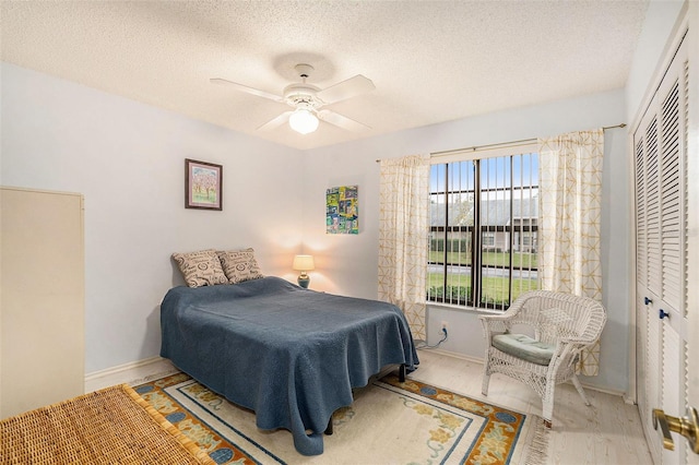 bedroom with ceiling fan, a closet, and a textured ceiling