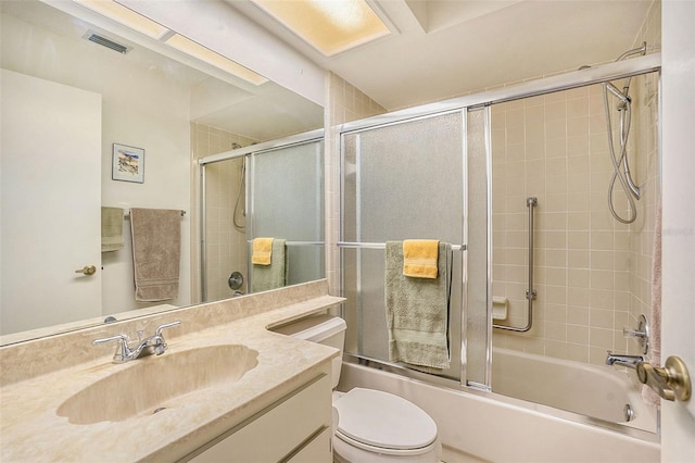 full bathroom with vanity, enclosed tub / shower combo, and toilet