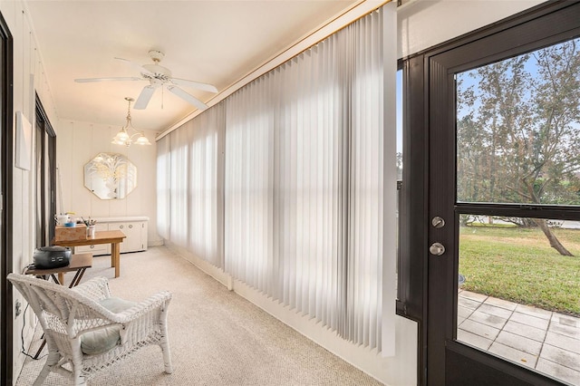 sunroom featuring ceiling fan with notable chandelier