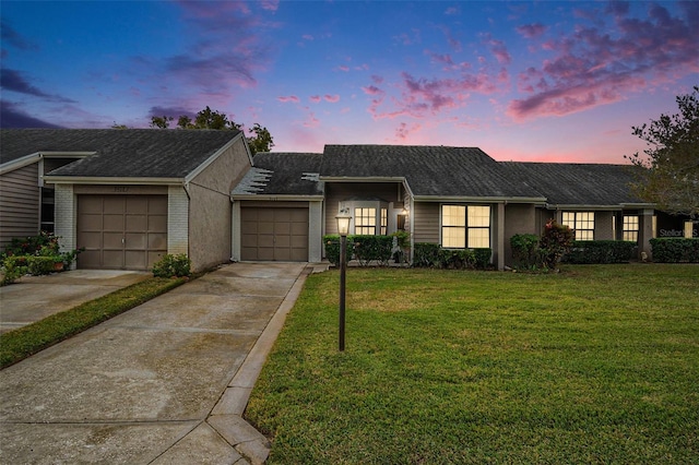 ranch-style house with a yard and a garage