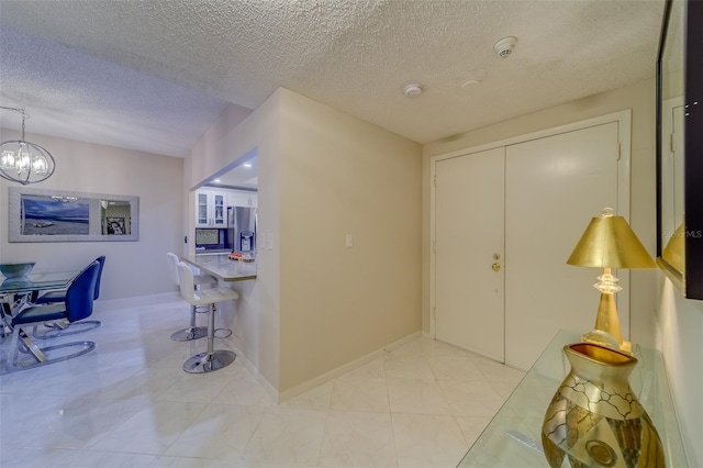 foyer featuring a textured ceiling and an inviting chandelier