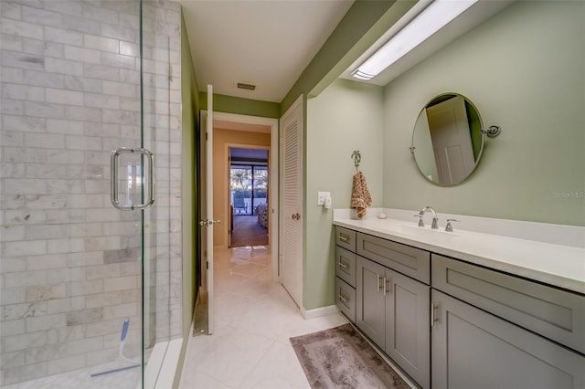 bathroom featuring tile patterned flooring, vanity, and walk in shower