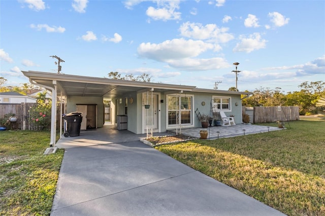 ranch-style home featuring a front yard and a carport