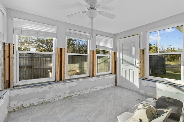 unfurnished sunroom featuring ceiling fan