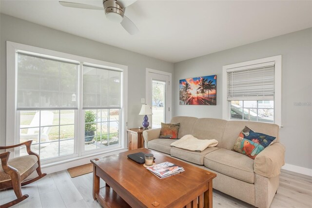 living room featuring light wood-type flooring, plenty of natural light, and ceiling fan